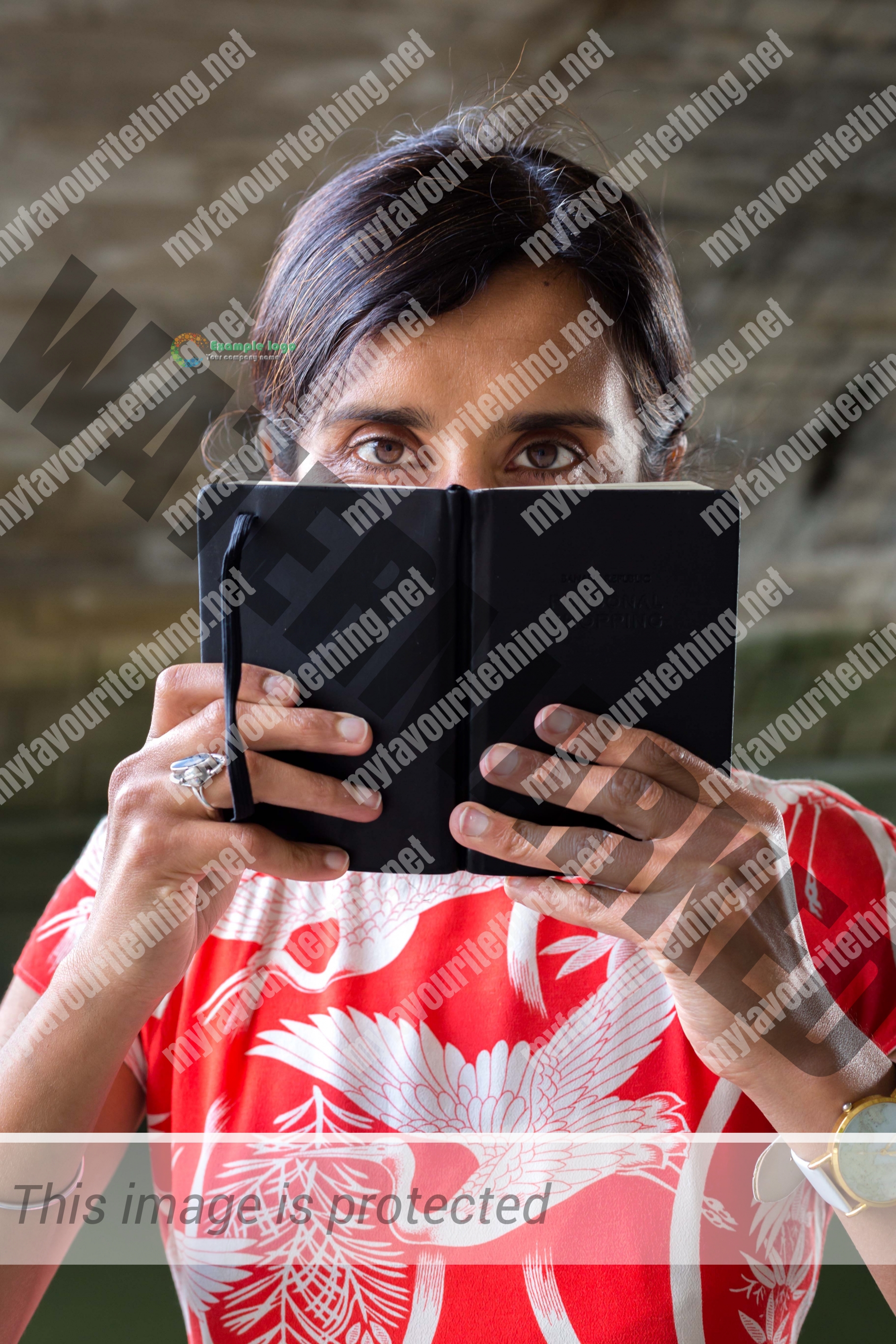 Lovejit Dhaliwal looking over the top of her notebook