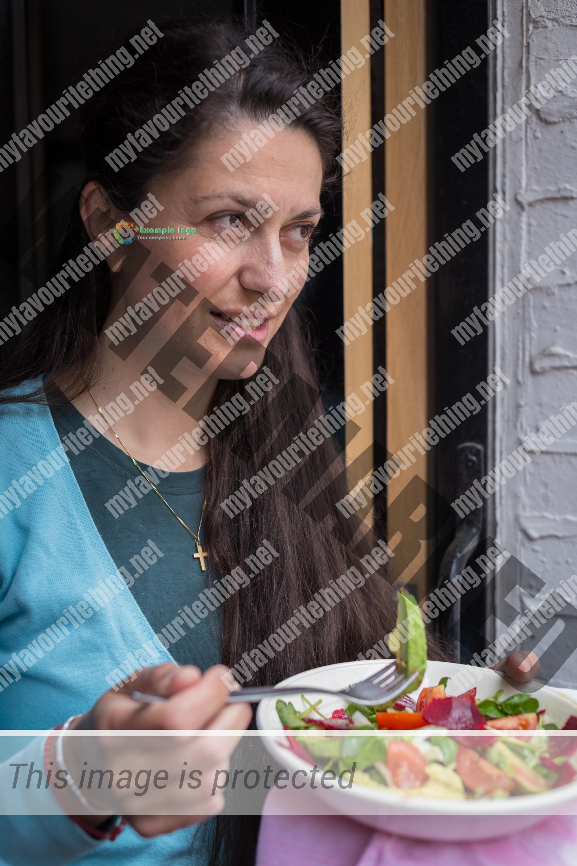 Woman holding a fork and bowl of salad
