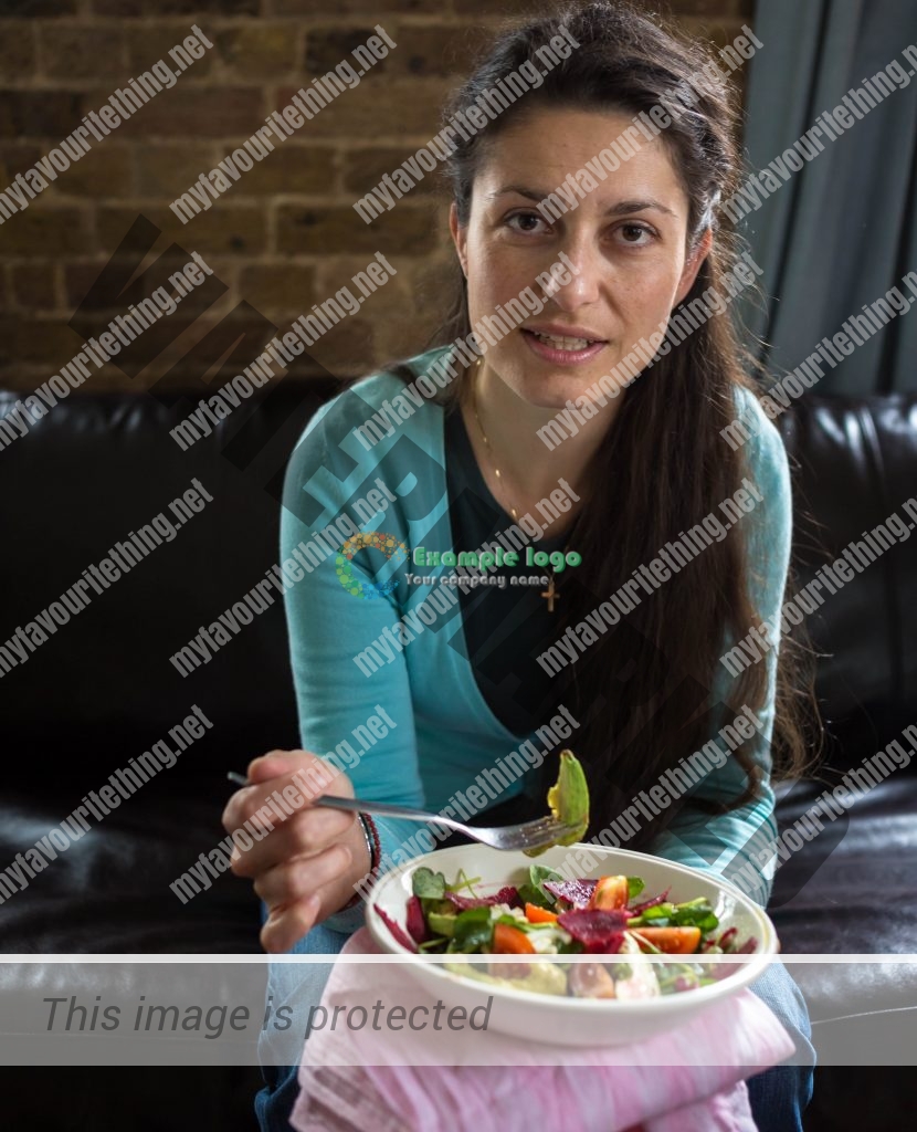 Engaging portrait of a woman holding a fork and a bowl of salad